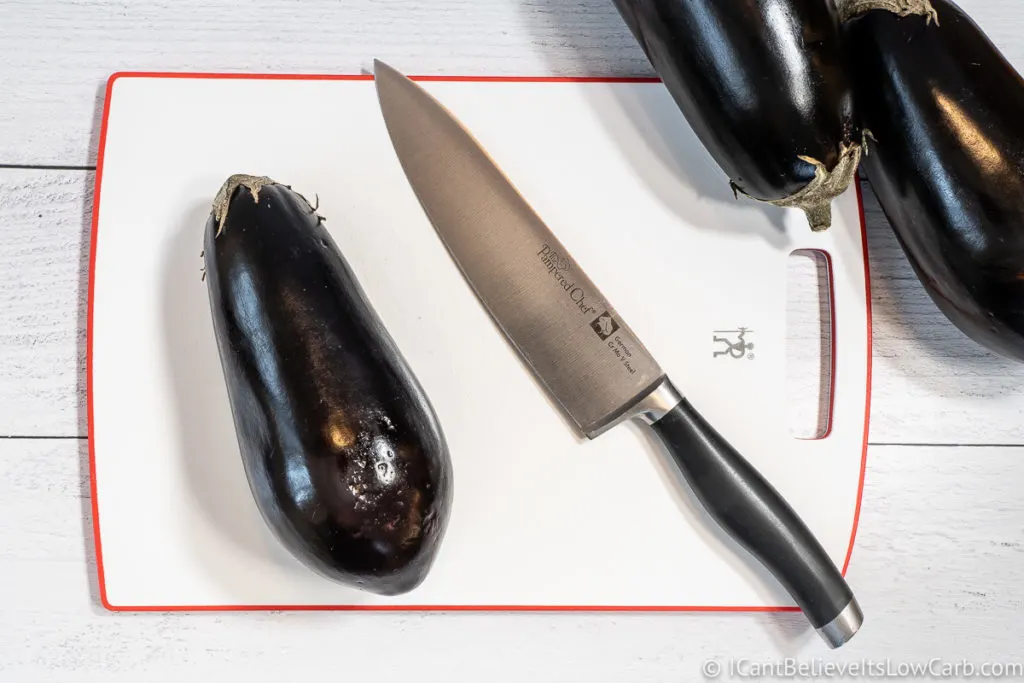 Eggplant on a cutting board with knife