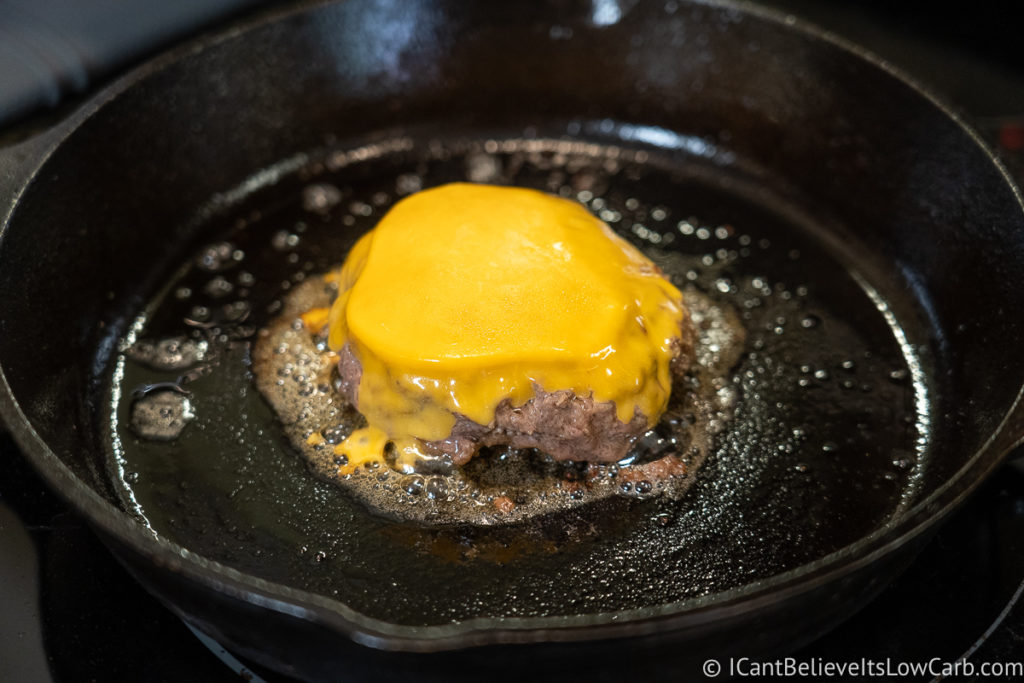 Hamburger cooking on the stove with melted cheddar cheese