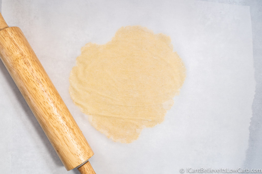 flattening the dough with a rolling pin