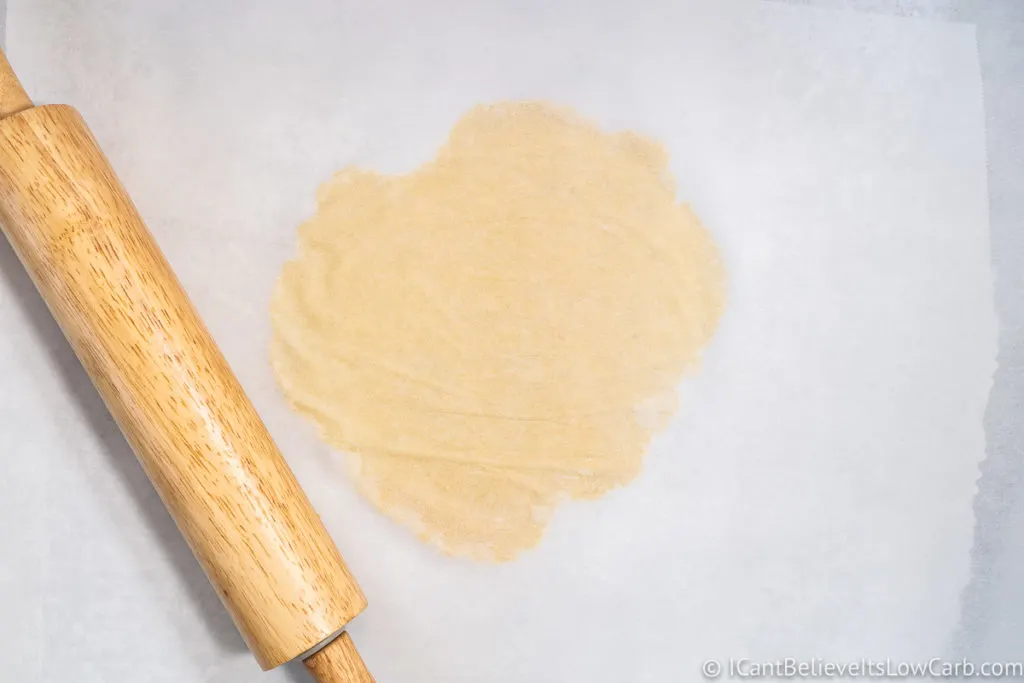 flattening the dough with a rolling pin