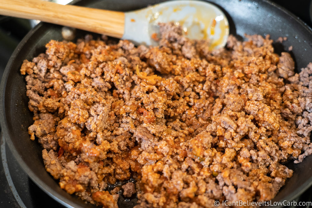 mixing in tomato sauce to ground beef