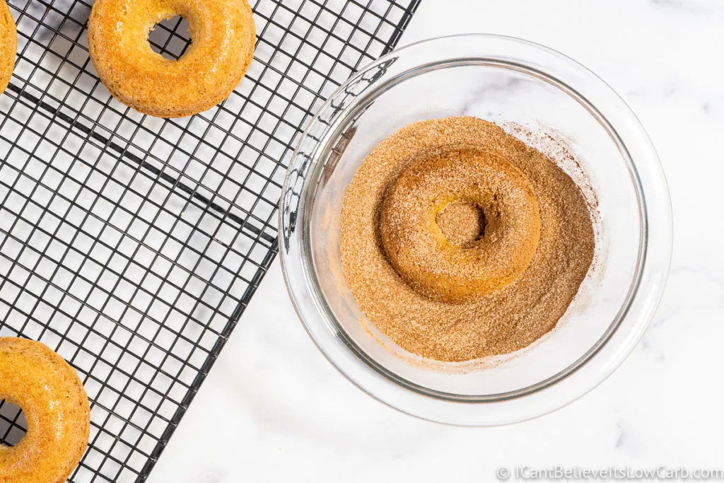 coating donuts in cinnamon sugar