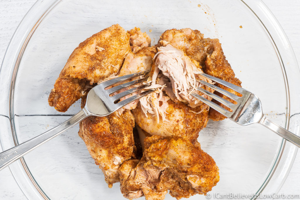 pulling apart chicken with forks