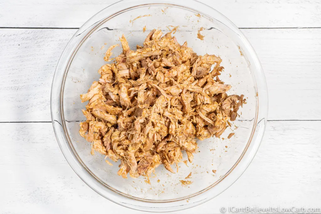 pulled apart chicken in glass bowl