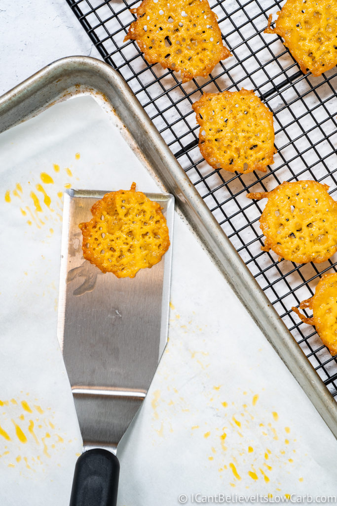 Scooping Keto Cheese Crisps onto a cooling rack
