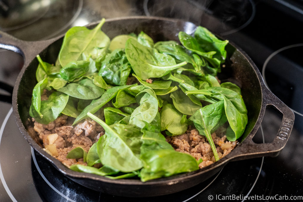 adding spinach to the pan