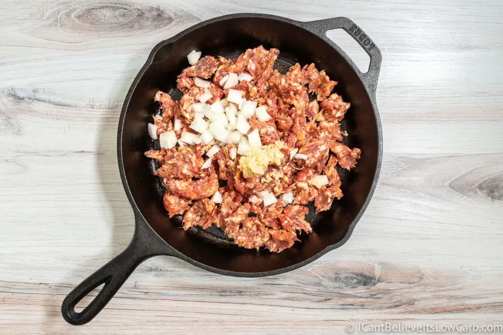 Adding sausage onions and garlic to cast iron frying pan