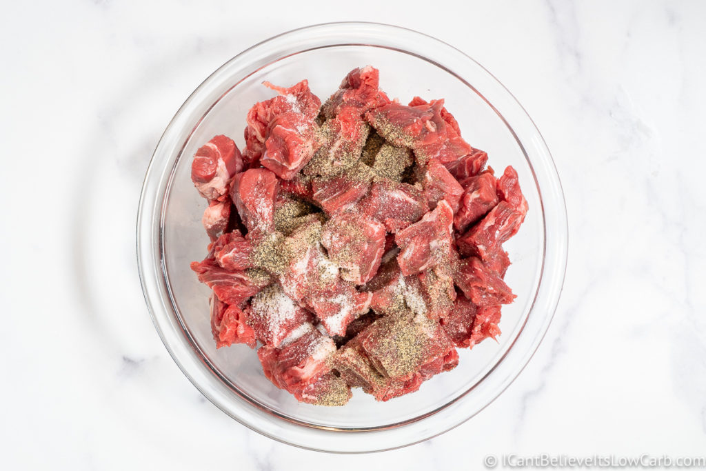 Chopped beef in a bowl with salt and pepper