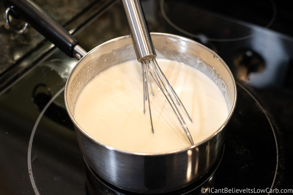 Stirring Alfredo sauce on the stove
