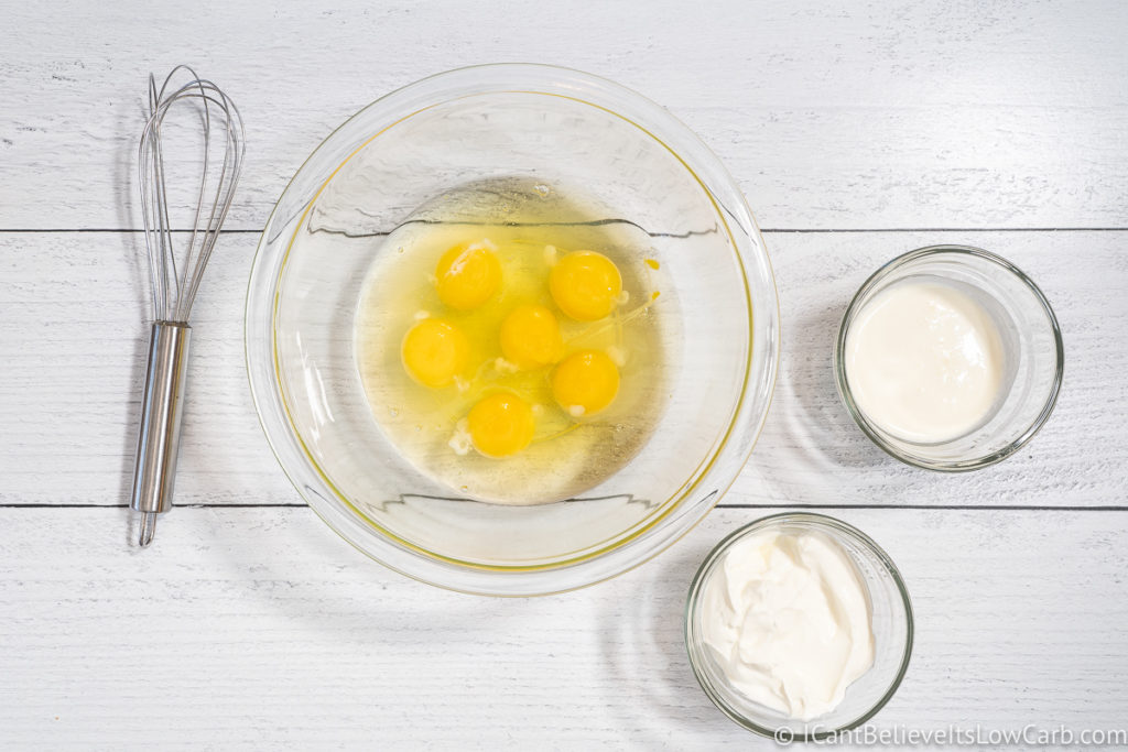 eggs sour cream and heavy cream in three bowls