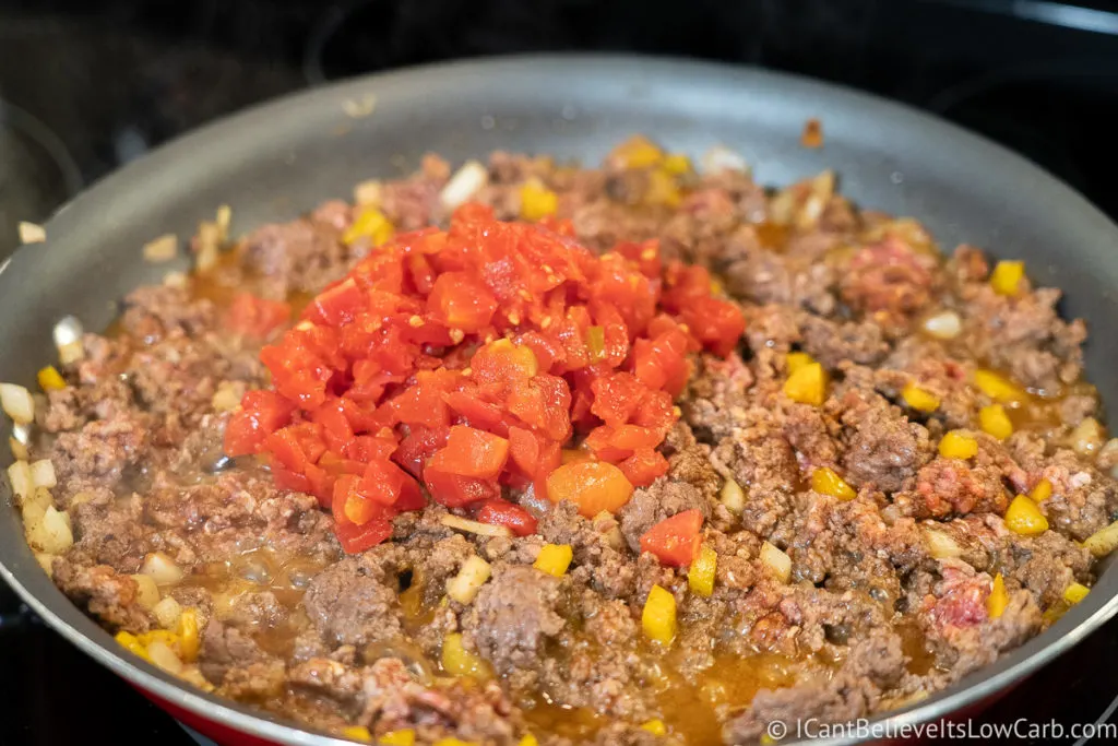 adding the tomatoes to the pan