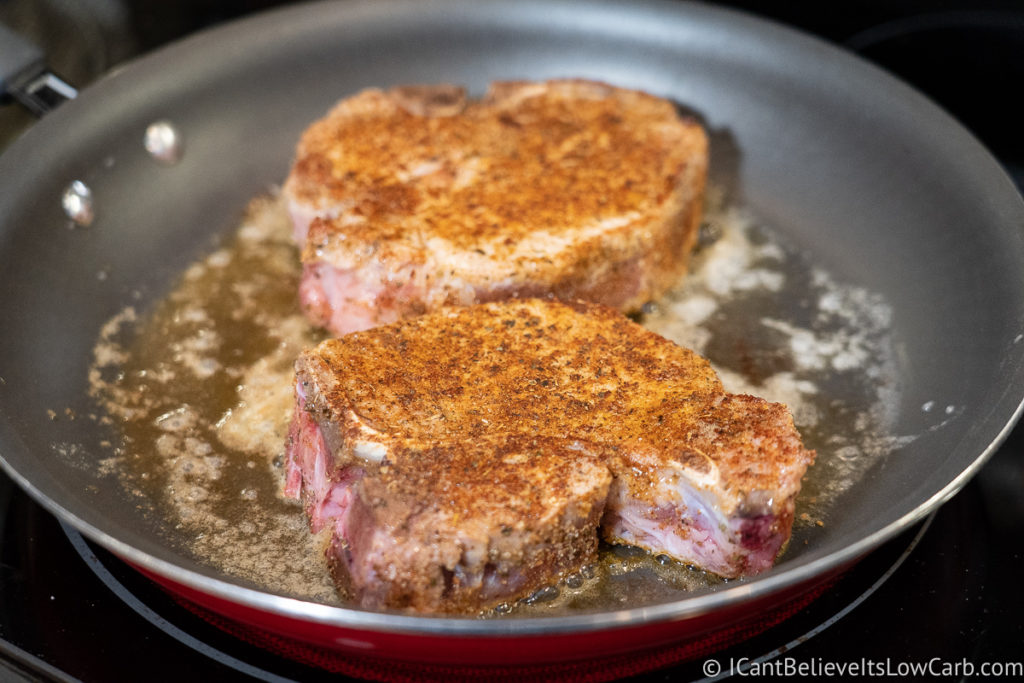 Searing Pork Chops in a frying pan on the stove