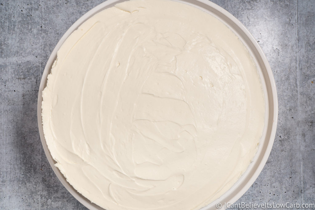 Smoothing the cheesecake mixture on the crust