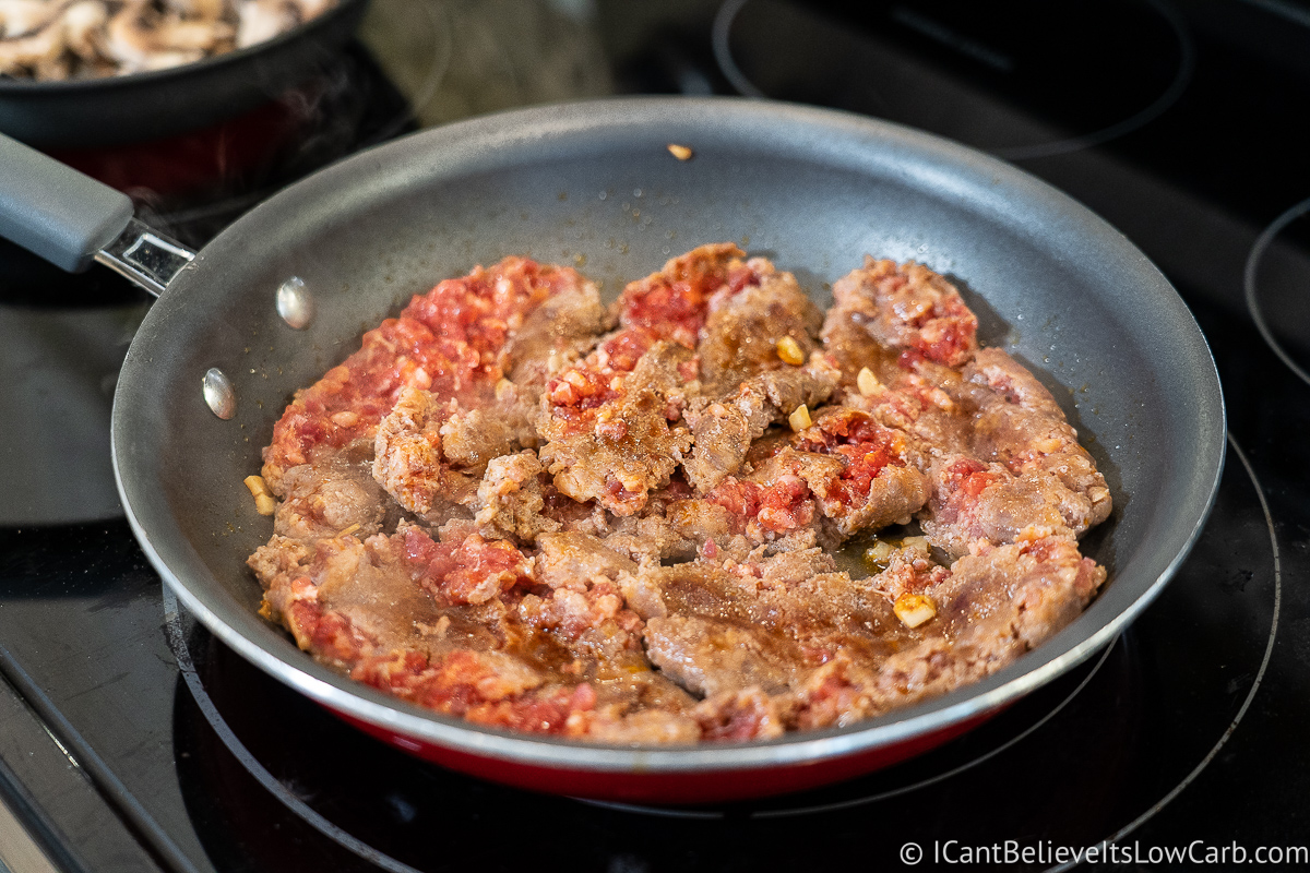 frying sausage in a pan for pizza casserole